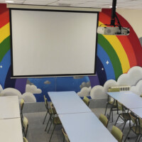 Proyector y pantalla en comedor de centro educativo. Proyector y pantalla en comedor de centro educativo.