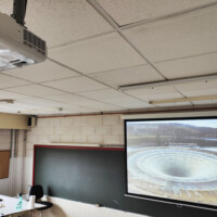 Proyector y pantalla en aula de formación. Proyector y pantalla en aula de formación.